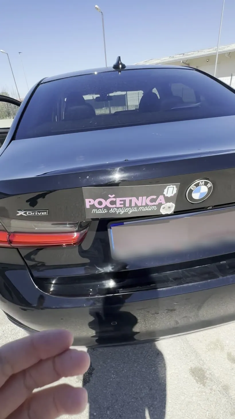 Tabla „Početnica” na gepeku crnog BMW-a