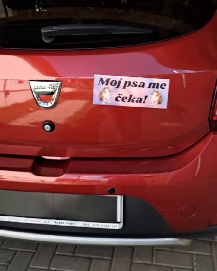 Crveni auto sa tablom „Moj psa me čeka!”