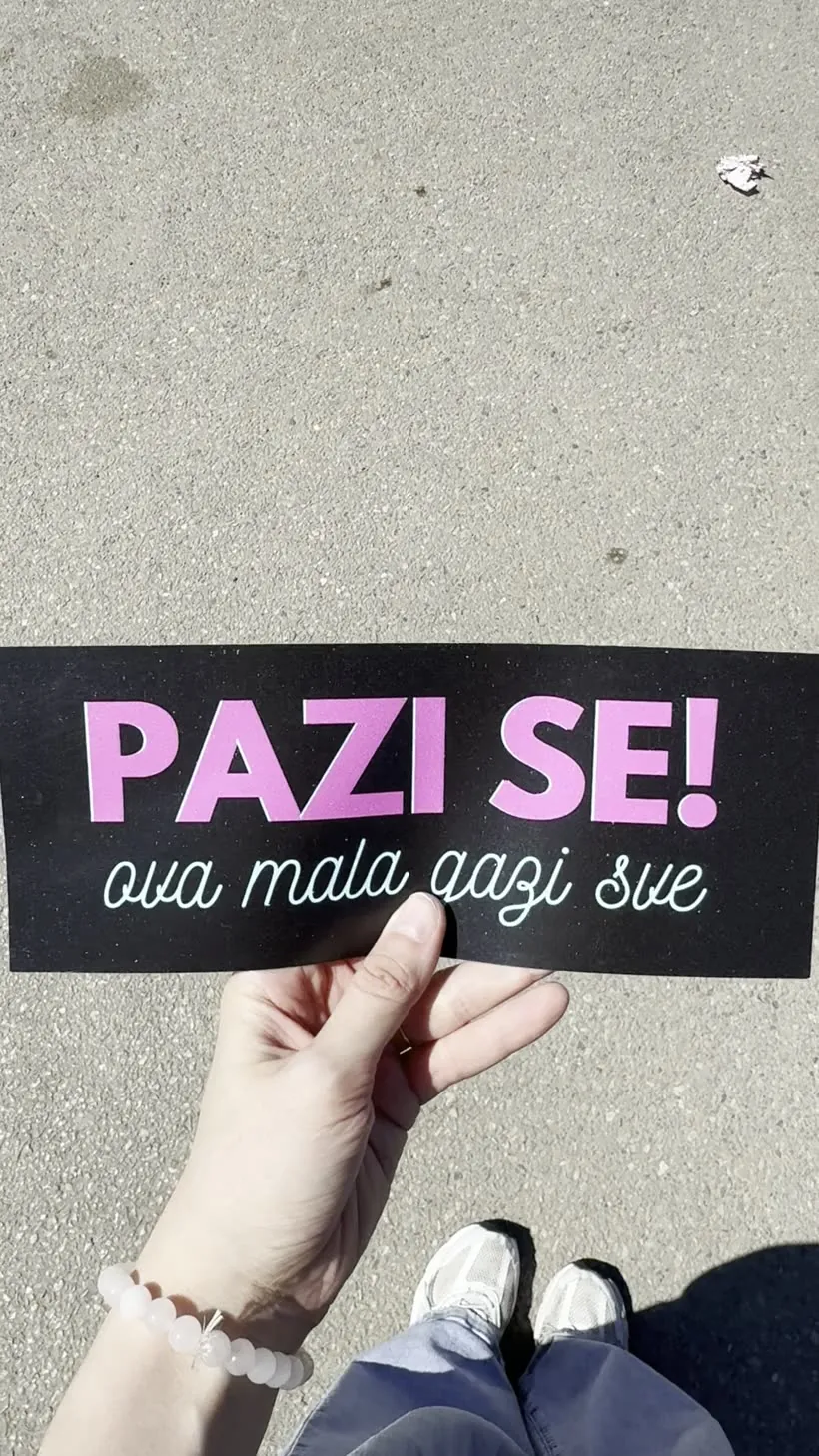 Ruka drži magnetnu tablu „Pazi se! ova mala gazi sve”